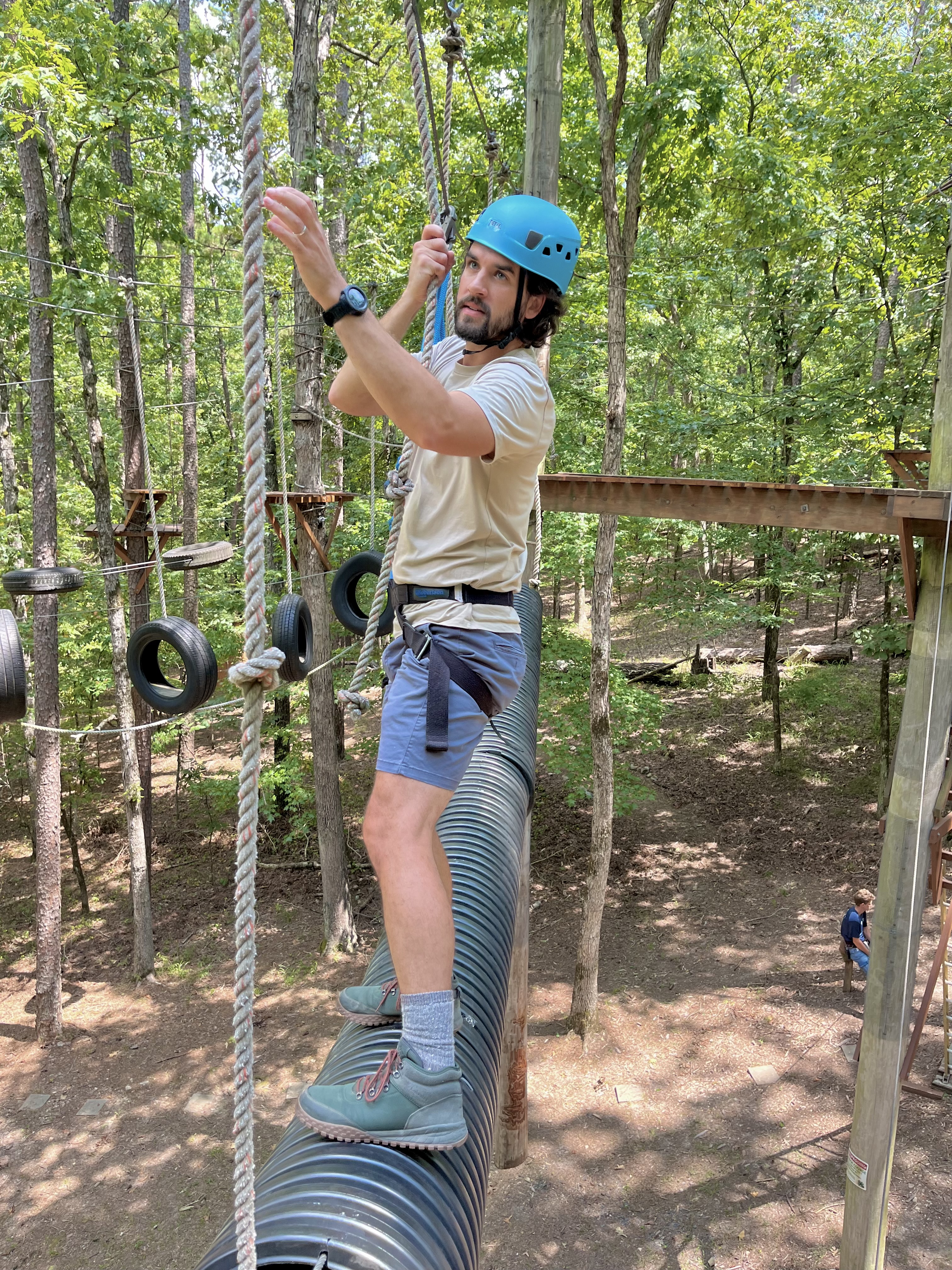 Participant moving across the "floating bridge" on the ropes course 